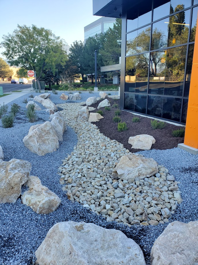Modern commercial plaza landscape with paver walkways and accent lighting